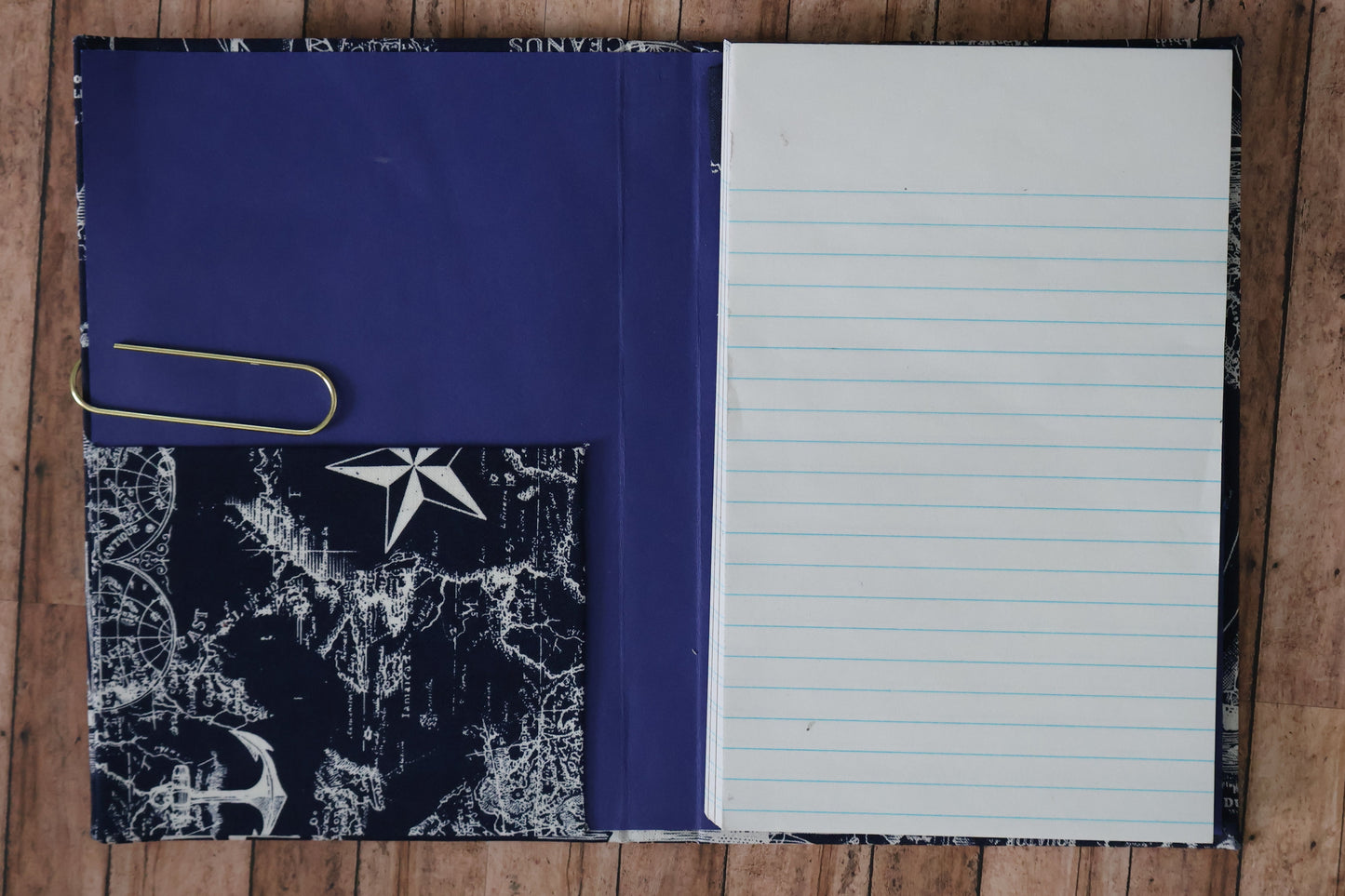 Notebook with lined pages and starfish pattern on a wooden surface