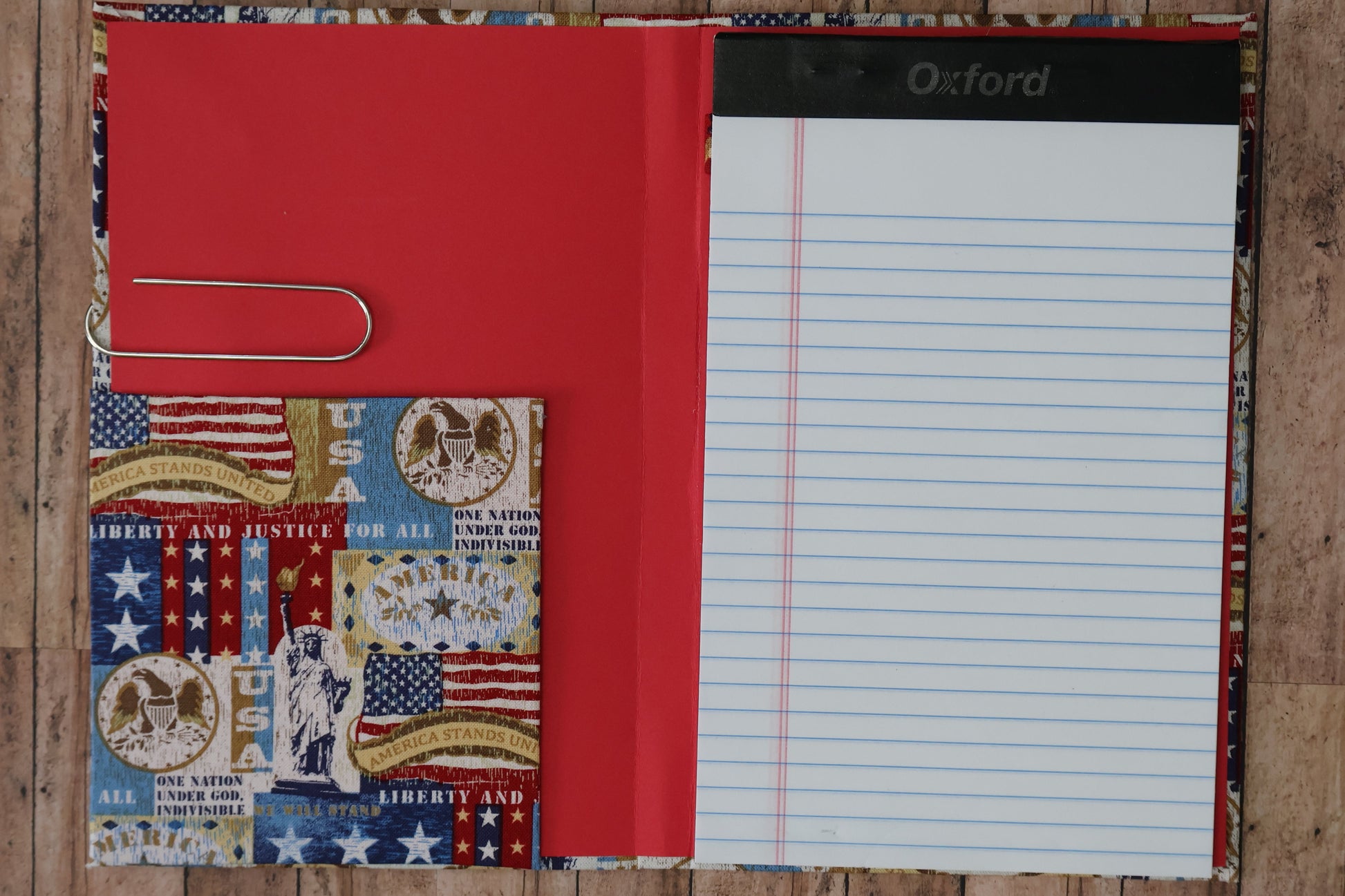 Notebook with a red cover and patterned back on a wooden surface