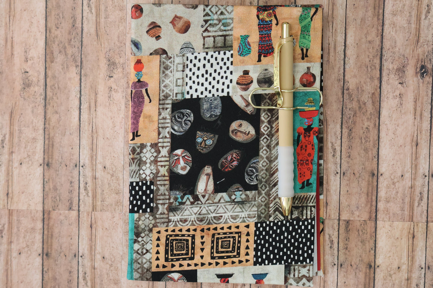 Picture of a notebook with African mask, African woman wearing a dress and various other designs.