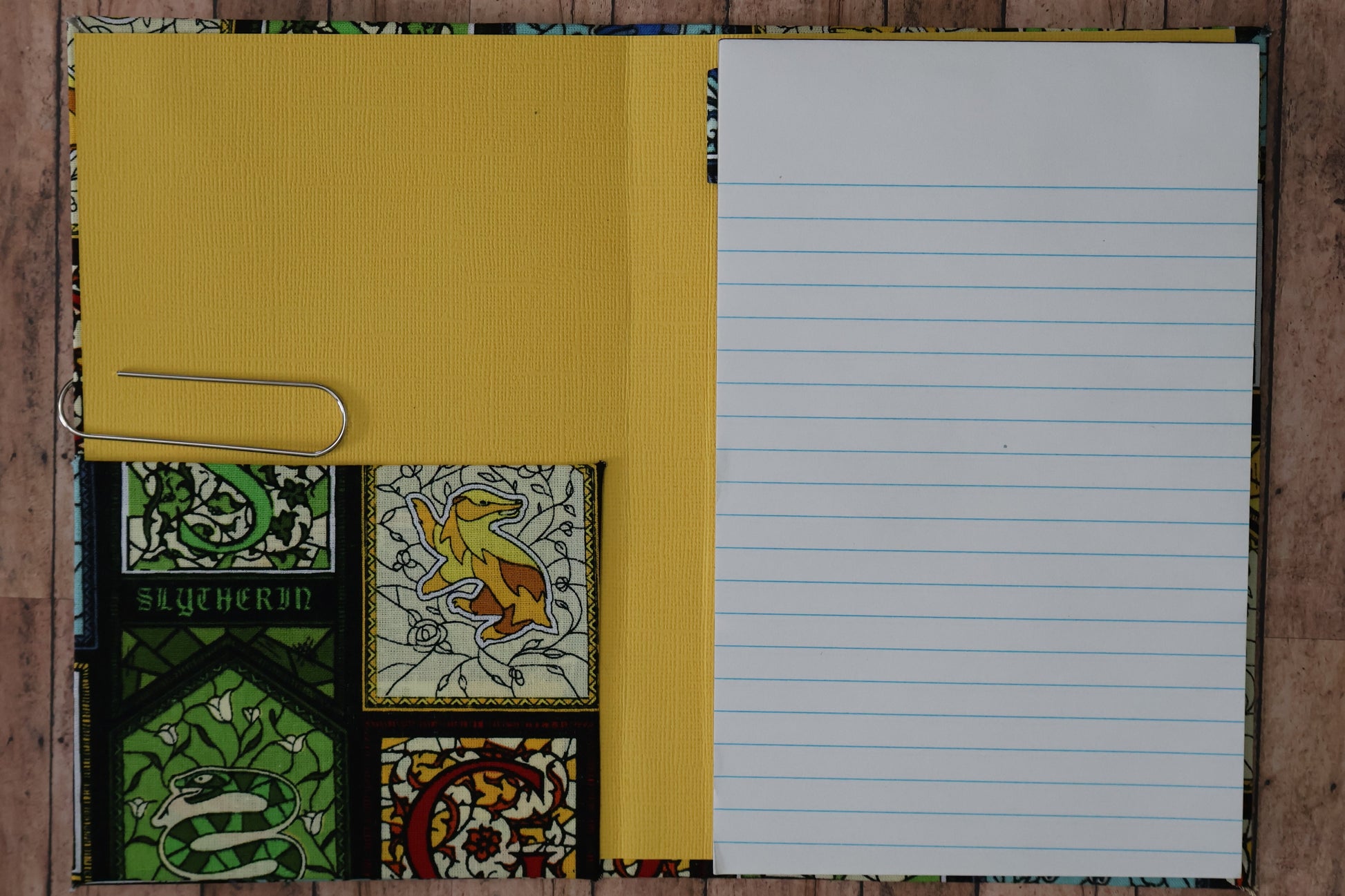 Notebook with different colored pages on a wooden surface