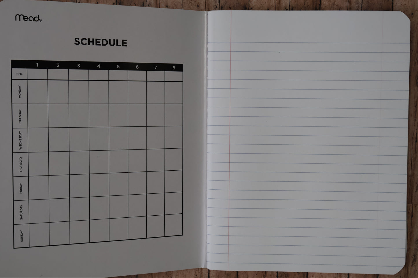 Notebook with lined pages and a grid on a wooden surface