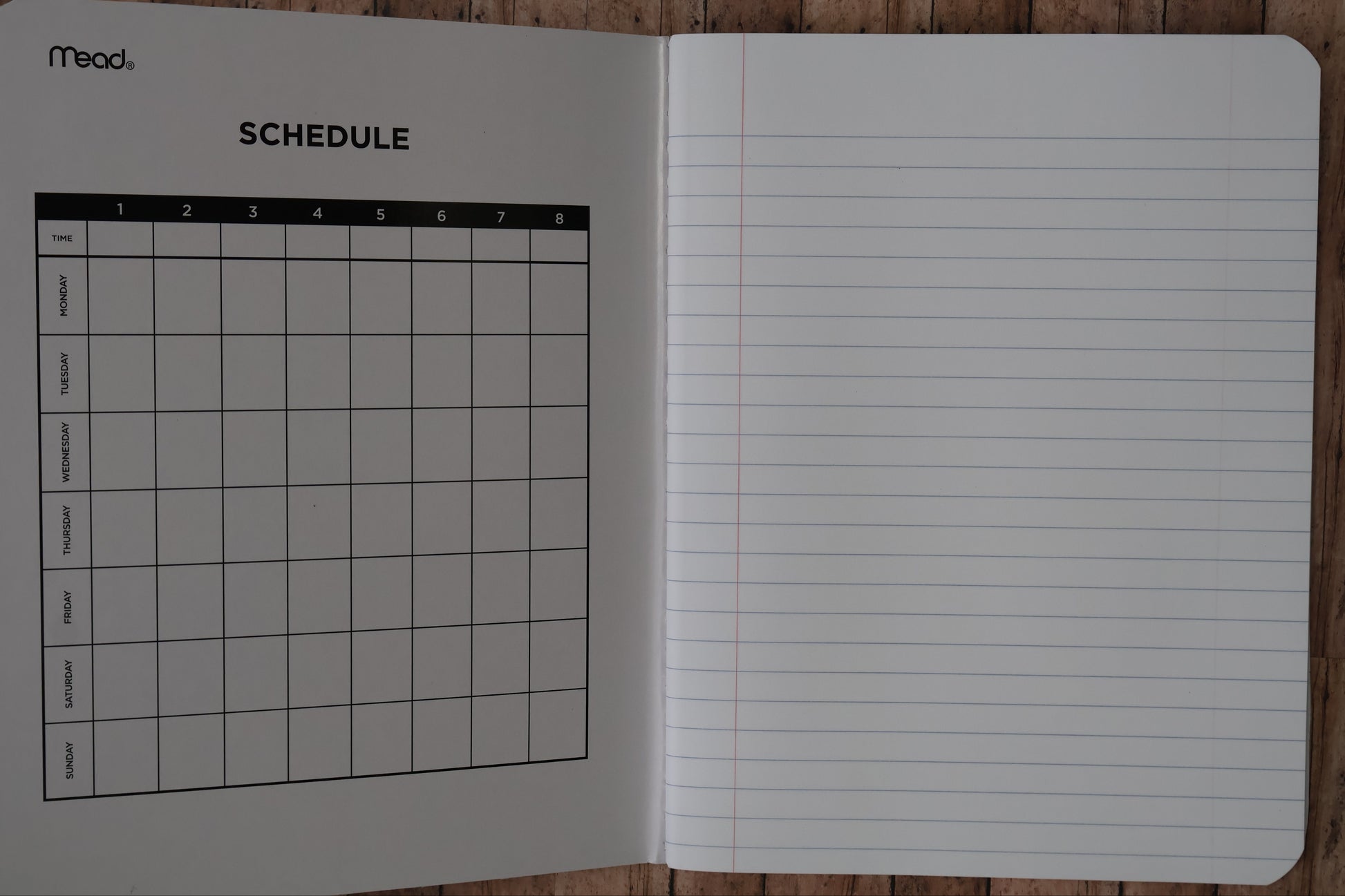 Notebook with lined pages and a grid on a wooden surface