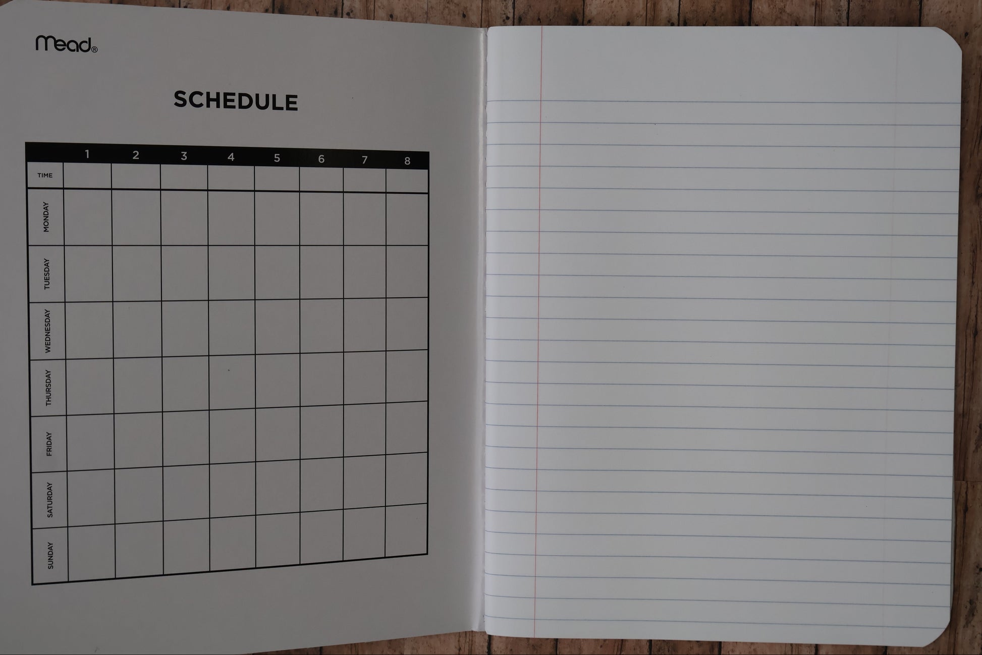 Notebook with lined pages and a grid on a wooden surface