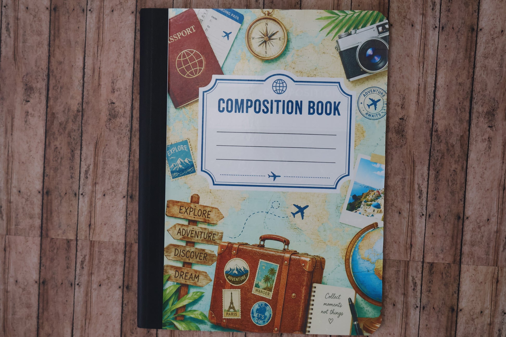 Composition book with travel-themed cover on a wooden surface